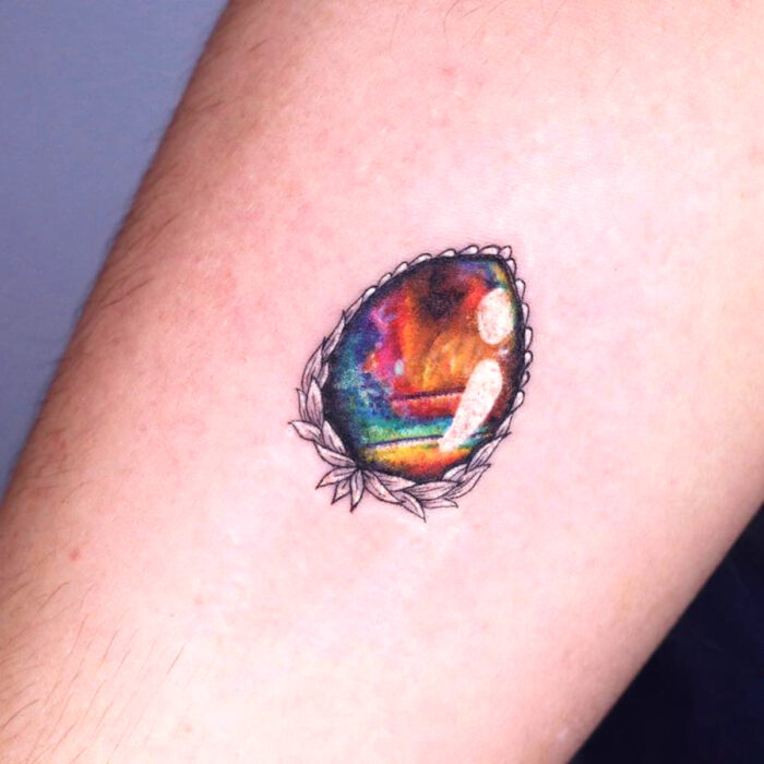 Diseños estupendos de tatuajes de joya de arcoíris en el brazo