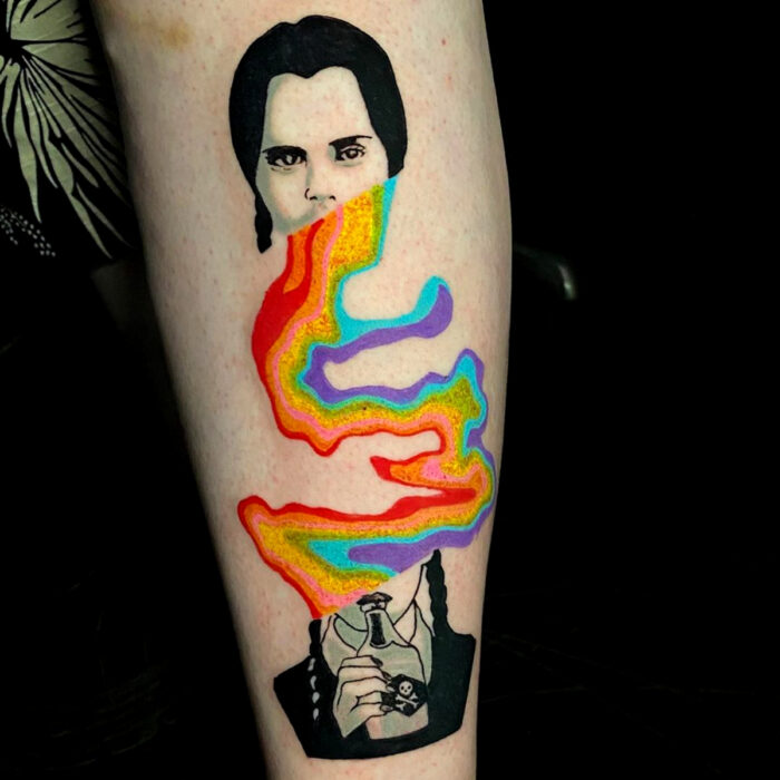 Diseños geniales de tatuajes de Merlina Addams con arcoíris en el brazo