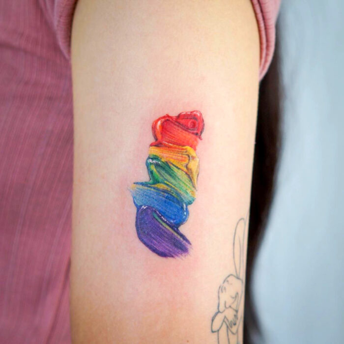Diseños artísticos de tatuajes de pintura al óleo de arcoíris en el brazo