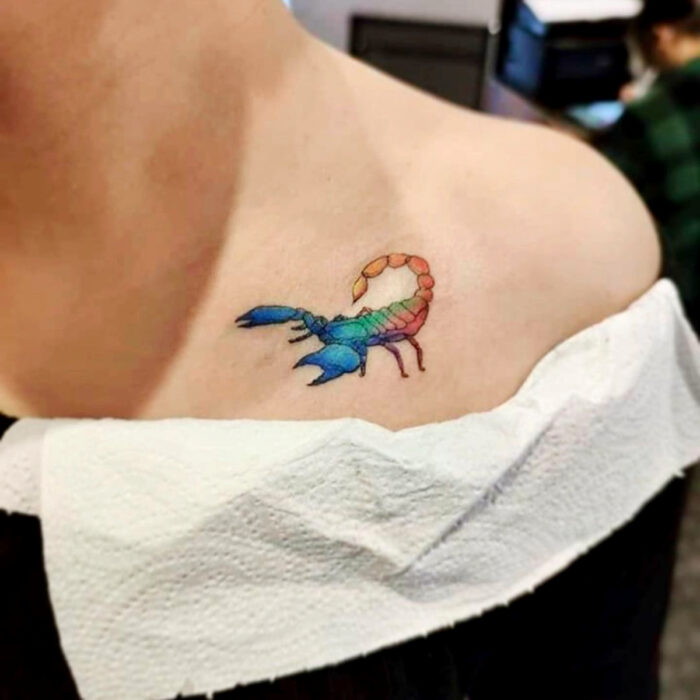Diseños únicos de tatuajes de escorpión de colores arcoíris en la clavícula