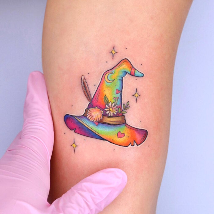 Diseños chulos de tatuajes de sombrero de bruja de colores arcoíris en el brazo