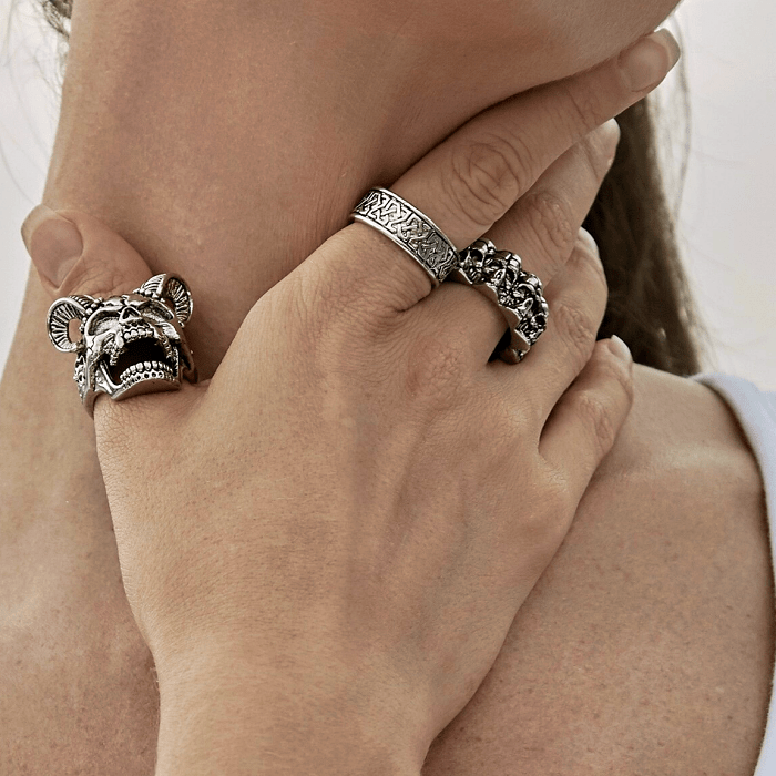 anillos plateados gruesos metálicos con diseño de calavera, cadenas y cuadraro