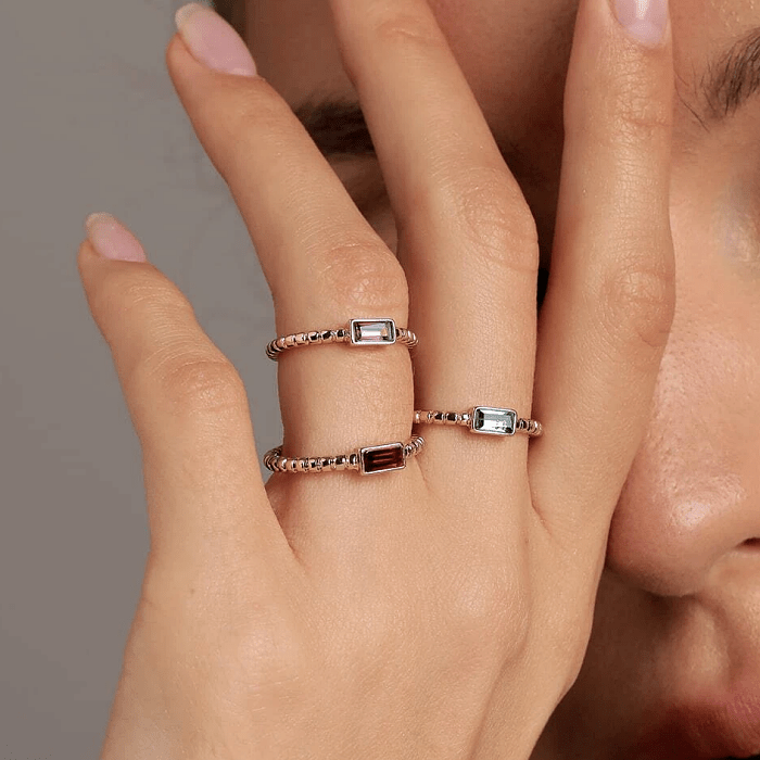 anillos dorados y plateados con piedras azules, negras y blancas