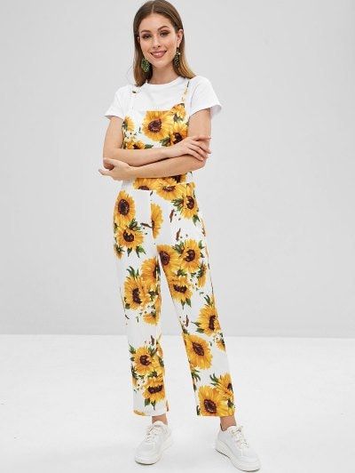 Chica llevando overol blanco con estampado de girasoles