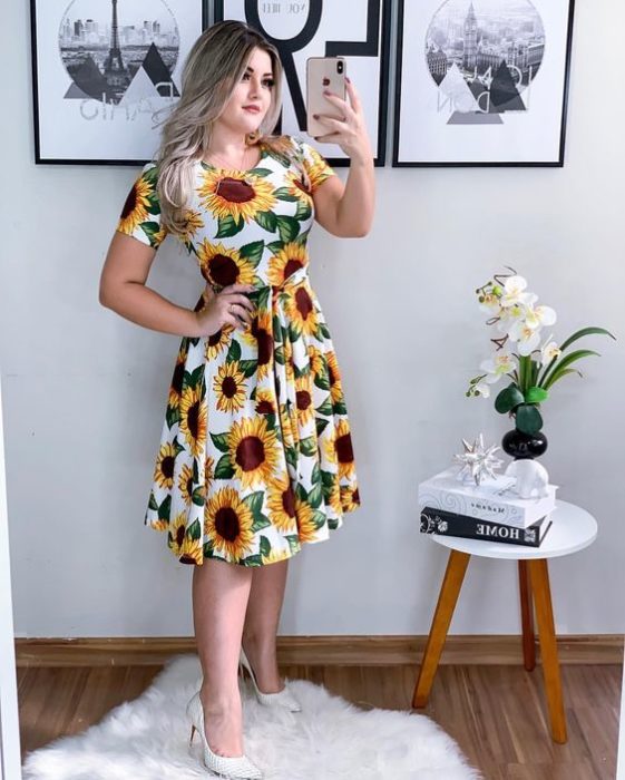 Chica llevando vestido blanco con girasoles al frente
