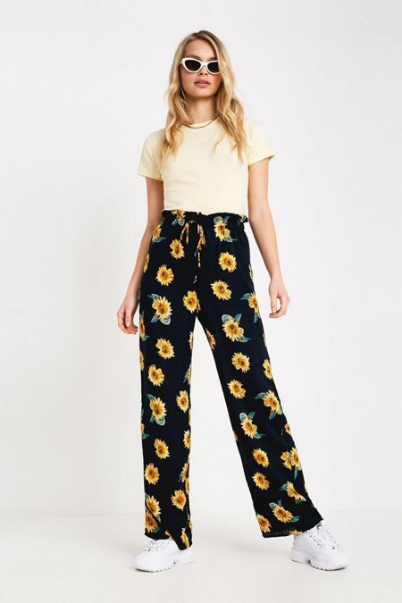 Chica llevando pantalones anchos en color negro con estampado de girasoles