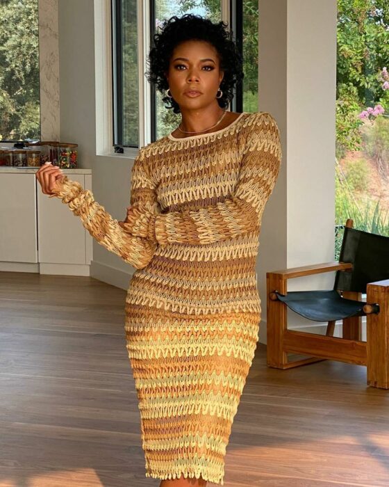 Gabrielle Union posando para una fotografía mientras usa un vestido de color mostaza