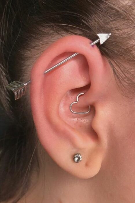 Chica con múltiples argollas en el oído, en forma de corazón; 13 Creativas maneras de llevar más de un piercing en el oído