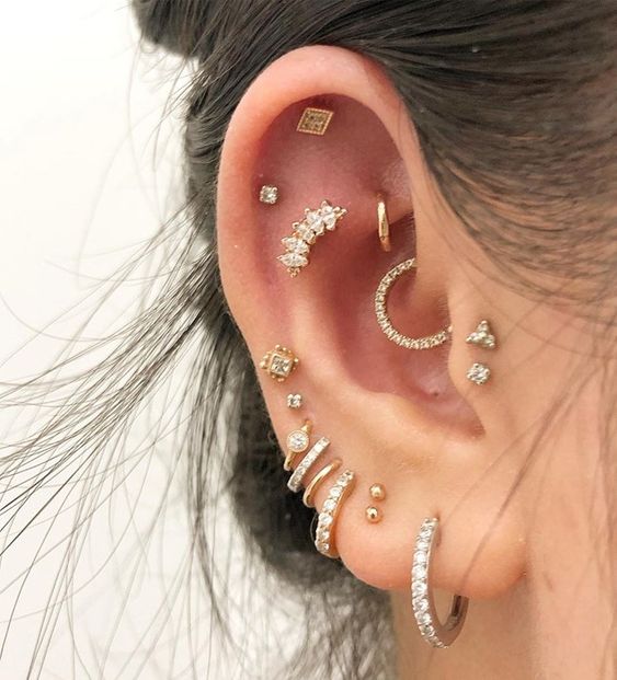 Chica con múltiples argollas en el oído, todos con piedras preciosas; 13 Creativas maneras de llevar más de un piercing en el oído
