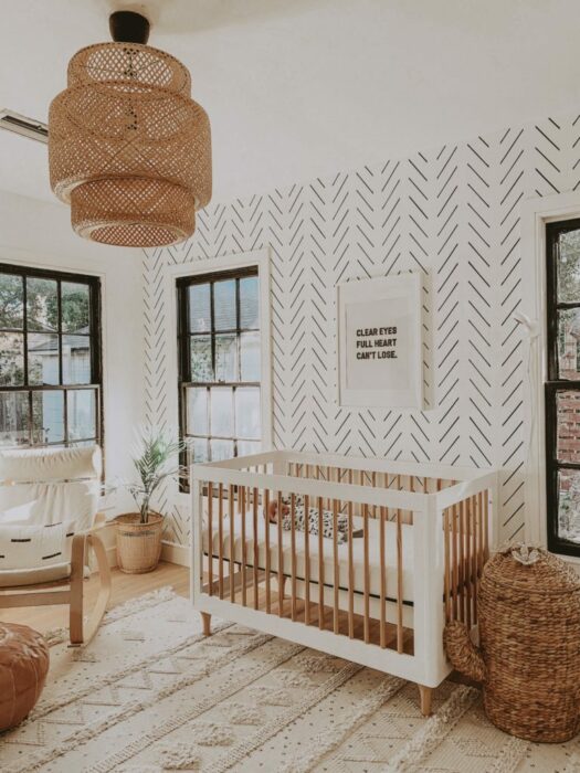 Decoración de la habitación de un bebé en tonos dorados con una cuna de madera de color blanco con café, mesa de luz y mueble para guardar artículos
