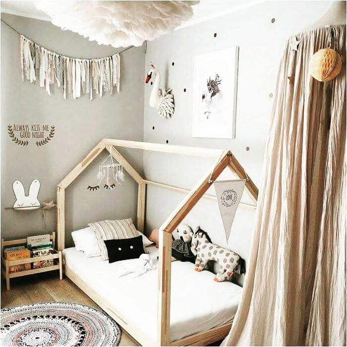 Recámara infantil decorada al estilo Montessori, con una cama baja y cortinas doradas