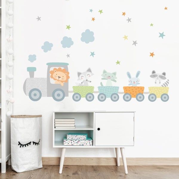 Pared de una habitación infantil decorada con un tren de animalitos, un mueble vintage blanco y un cesto de ropa