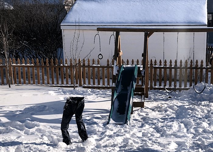 pantalones de mezclilla congelados en el jardín, rodeados de nieve por el frío