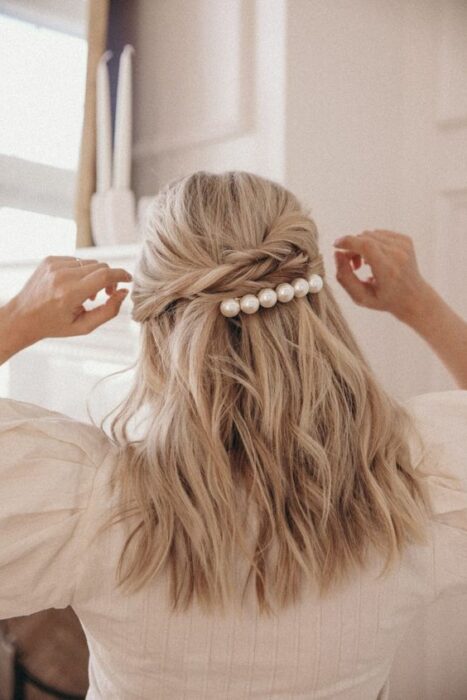 Chica de cabello rubio con un recogido adornado con broche de perlitas