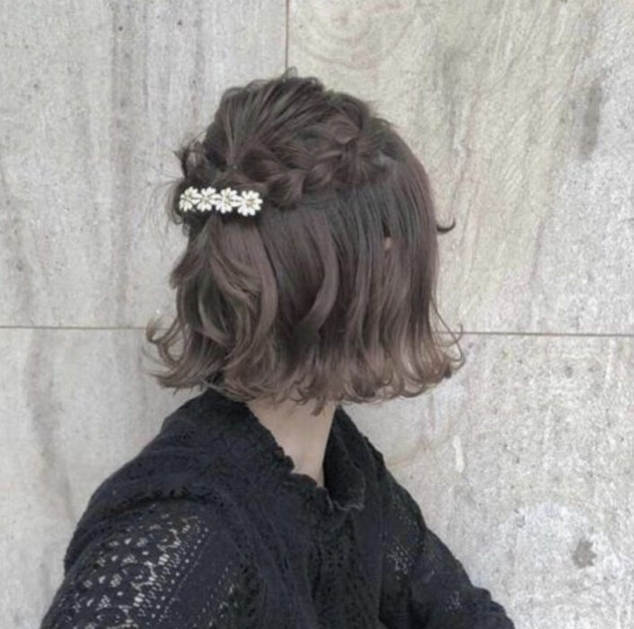 Chica de cabello negro corto con trencitas y un broche
