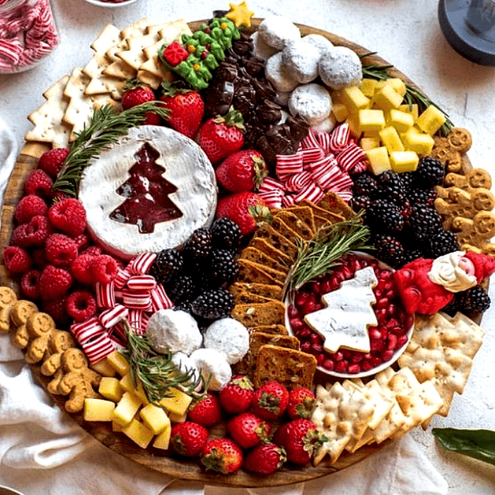tabla de quesos, embutidos, charcutería, uvas, salami, jamón serrano, con estilo navideño