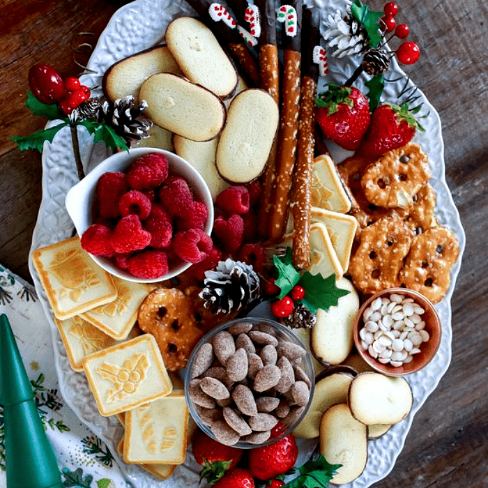 tabla de quesos, embutidos, charcutería, uvas, salami, jamón serrano, con estilo navideño