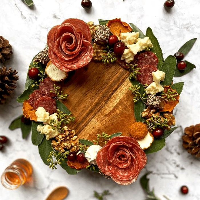 tabla de quesos, embutidos, charcutería, uvas, salami, jamón serrano, con estilo navideño