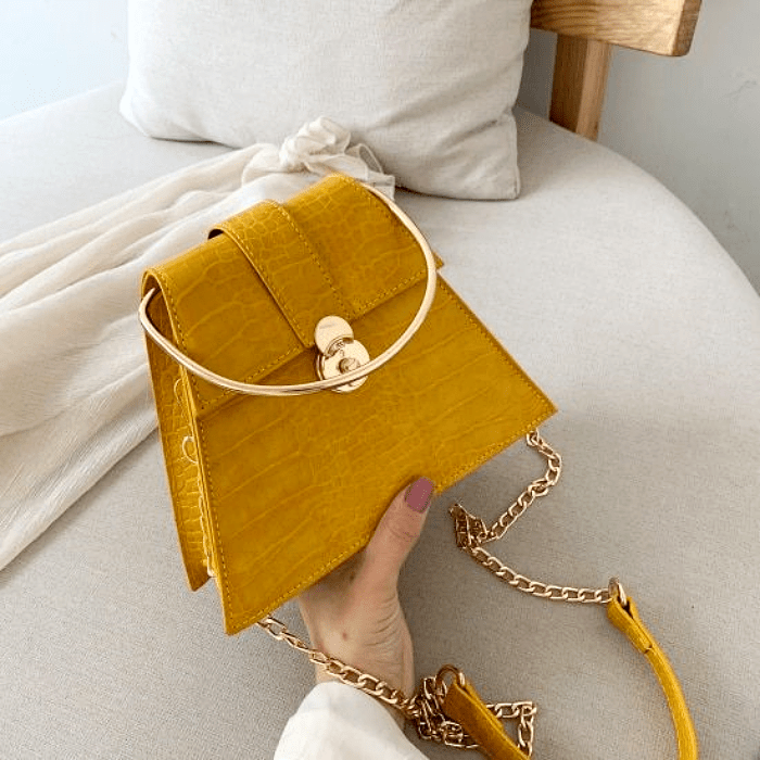 bolso amarillo con asa dorada y larga correa amarilla