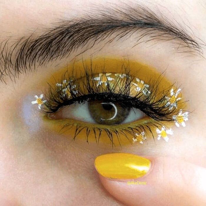 maquillaje de ojos amarillo con sombras claras y flores blancas