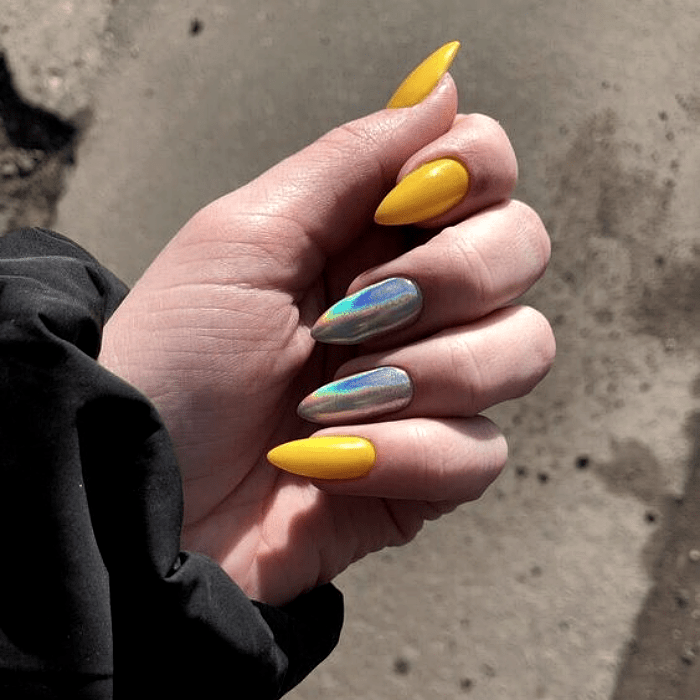 uñas acrílicas con esmalte amarillo y plateado brillante