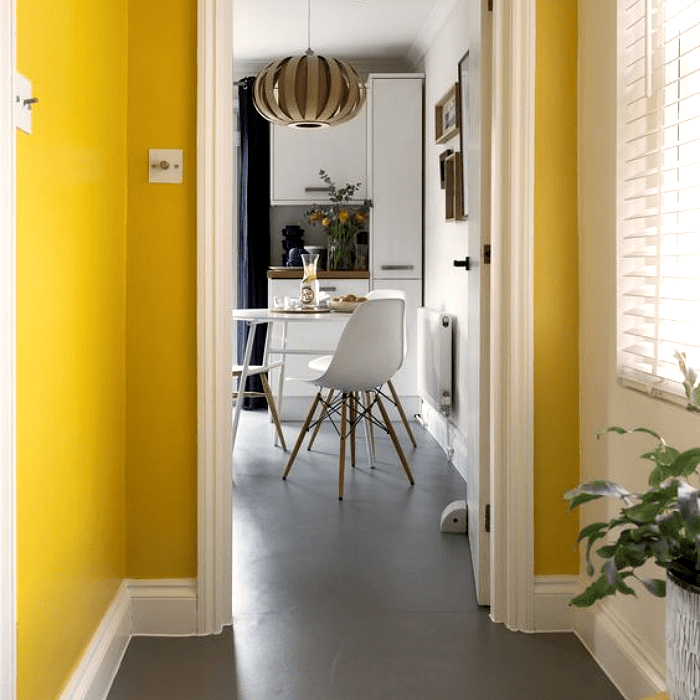 salón decorado en amarillo y gris, con muebles blancos