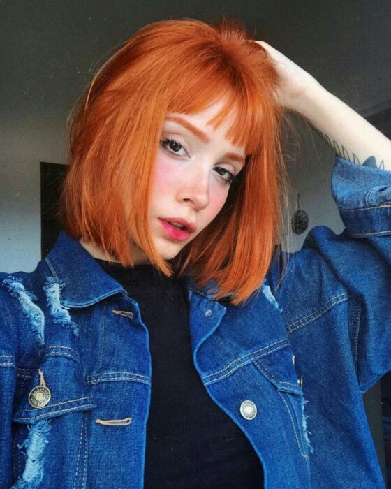 Chica con el cabello corto hasta la barbilla y teñido en color naranja