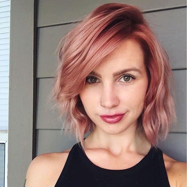 Chica con el cabello corto hasta la barbilla y teñido en color rose gold