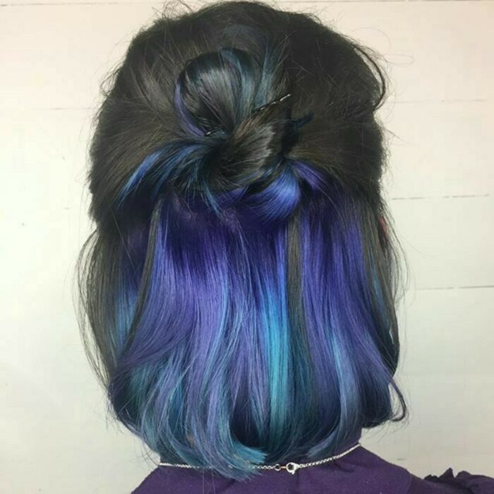 Chica con el cabello teñido en color negro con una cortina en color azul
