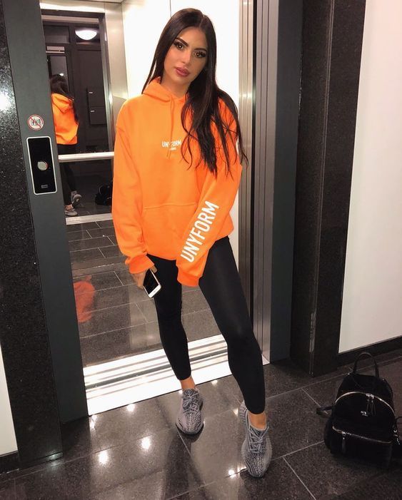 Chica llevando conjunto deportivo con sudadera en color naranja; Ideas para usar color naranja en tu outfit