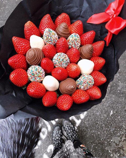 Ramos de fresas rojas, fresas cubiertas de chocolate blanco con chispas de colores y fresas con chocolate blanco envueltas con papel negro y un moño rojo