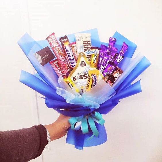 Ramos de chocolates, Kisses y Hersheys envueltos en papel azul con moño verde aqua