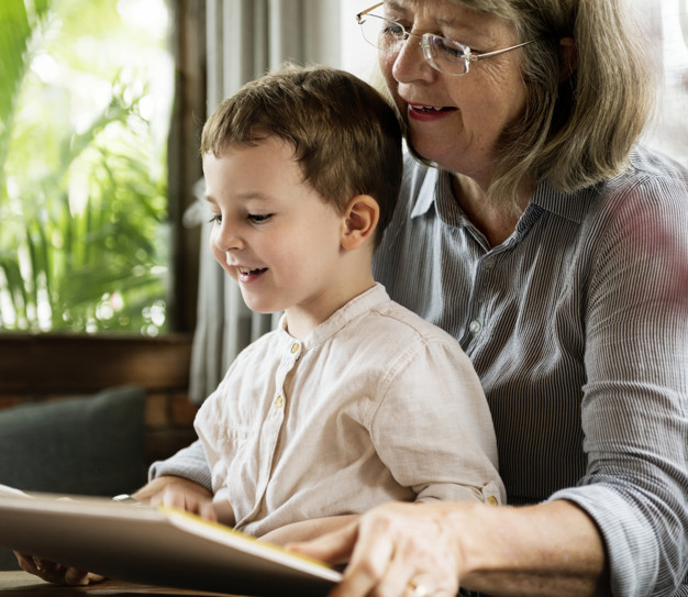 Abuela y nieto leen un libro juntos