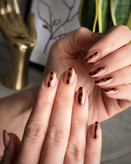 Manicura en diseño animal print con base transparente y líneas en cada dedo