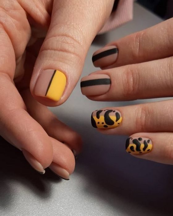Manicura en diseño animal print en negro y mostaza con efecto mate