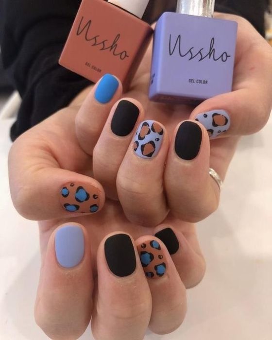 Manicura en diseño animal print con azules y negros, decorada en pulgar y dedo medio