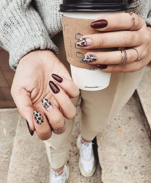 Manicura en diseño animal print en tonos cafés y decoraciones en varios dedos
