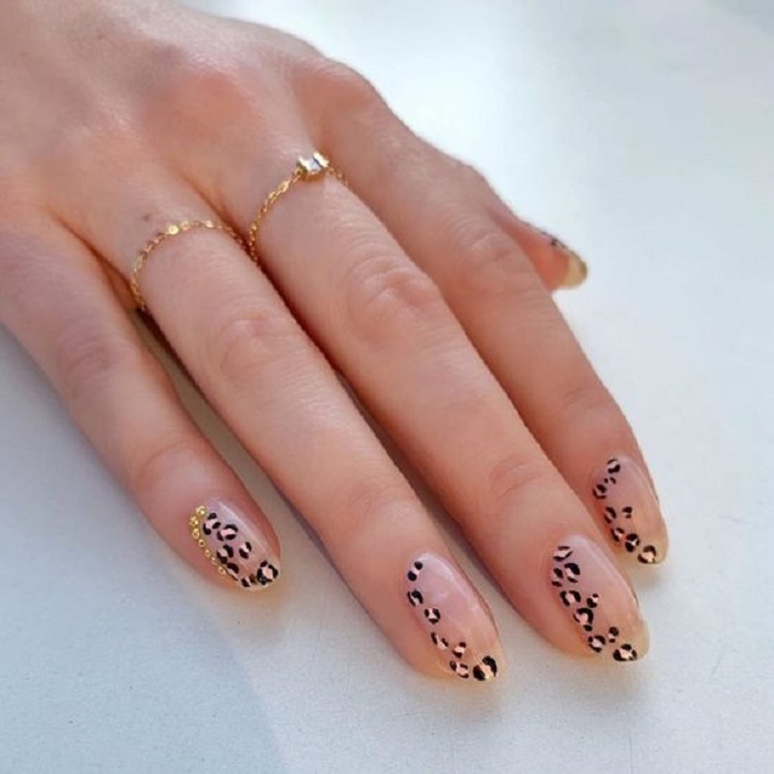 Manicura en diseño animal print con base transparente y decoración lateral