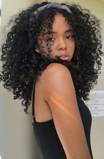Chica con cabello rizado peinado con una banda; Peinados para chicas de cabello rizado