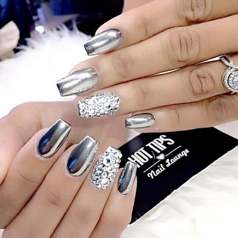 Chica con las uñas en un diseño metálico de color plateado con toques de piedras blancas