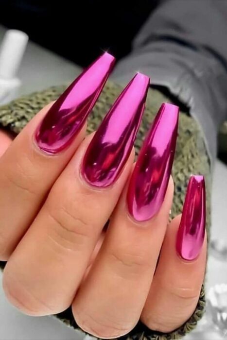 Chica con las uñas en un diseño metálico de color fucsia