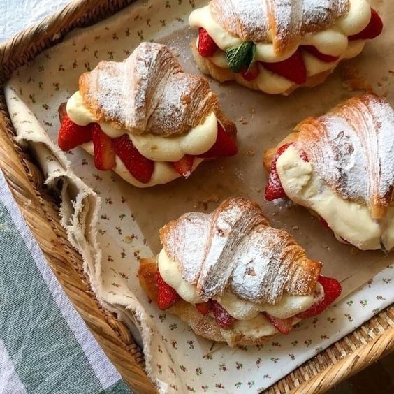 Croissants dulces rellenos de crema con fresa y espolvoreados de azúcar glass