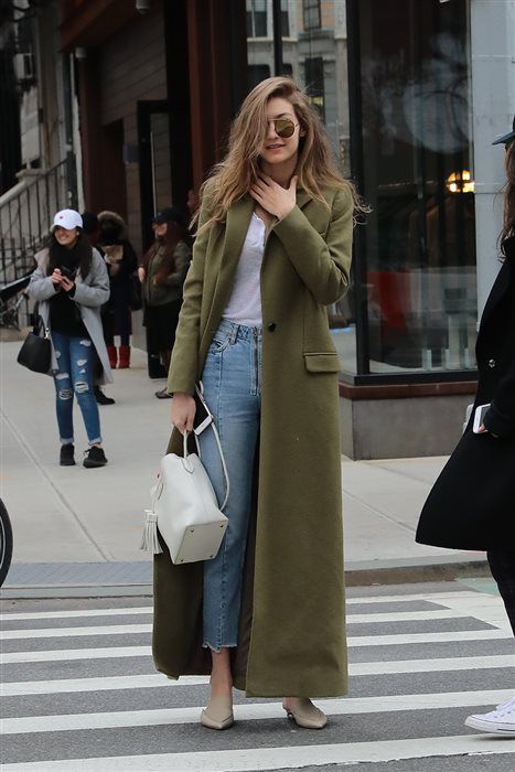 Chica usando mom jeans, playera blanca, bolso de mano blanco y abrigo largo color verde army
