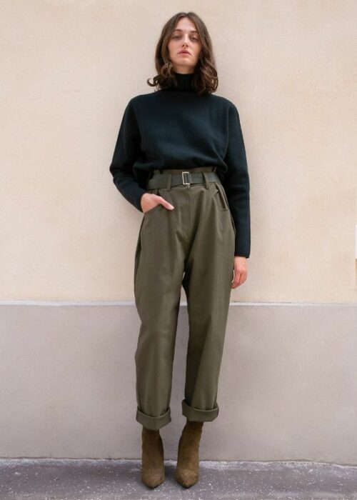 Chica usando botines café, suéter de cuello de tortuga negro y paper pants color verde army