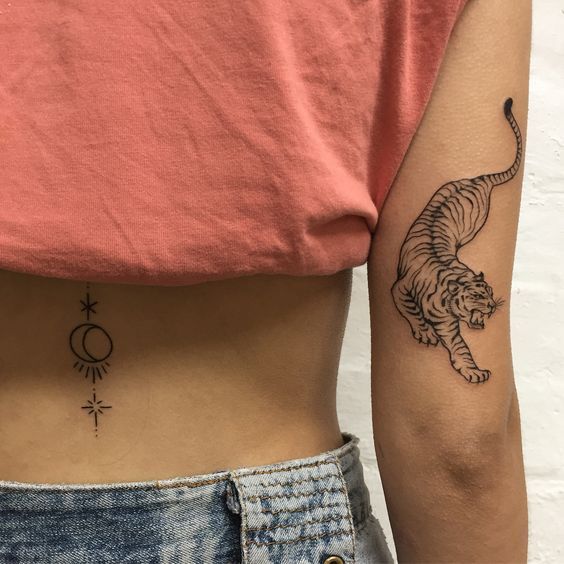 Tatuaje de tigre en tinta negra en la parte trasera del brazo