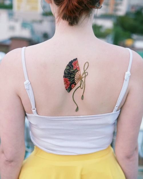 Tatuaje en la espalda de abanico asiático color negro y rojo