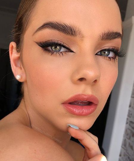 Chica con cabello castaño recogido y maquillaje foxy eyes