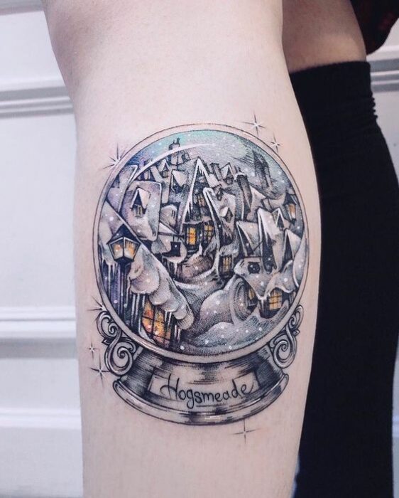 Chica con tatuaje de bola de cristal inspirado en Harry Potter; Tatuajes miniatura para las que aman la Navidad