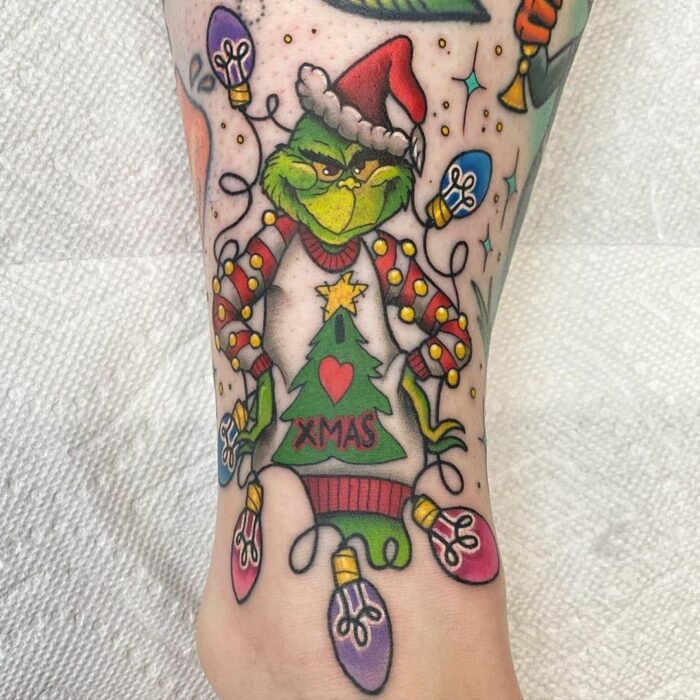 Chica con tatuaje del Grinch; Tatuajes miniatura para las que aman la Navidad