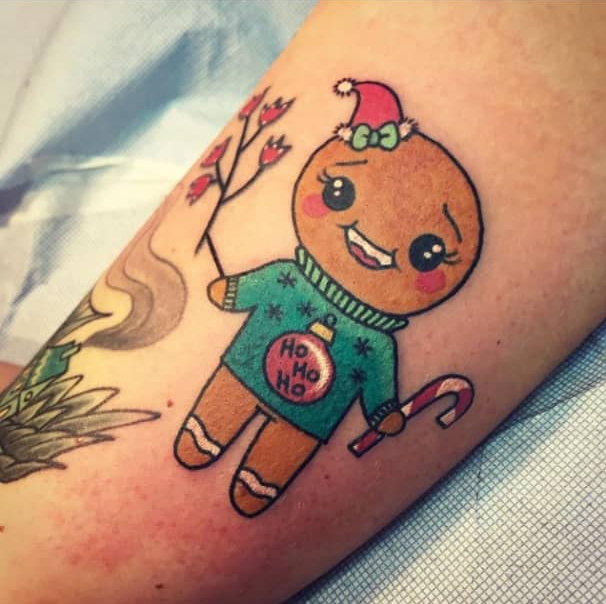 Chica con tatuaje de galleta de jengibre; Tatuajes para las chicas que aman Navidad
